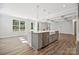 Gourmet kitchen boasts stainless steel appliances, gray cabinets, and a large island with sink at 133 Jentri Way, Mooresville, NC 28115