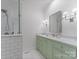Elegant bathroom featuring a double vanity with green cabinets, and a glass-enclosed shower with white subway tile at 4301 Fairview Oaks Dr, Charlotte, NC 28211
