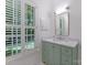 Well-lit bathroom with a marble countertop, green vanity, and plantation shutters, offering natural light and privacy at 4301 Fairview Oaks Dr, Charlotte, NC 28211