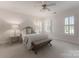 Bright bedroom with neutral walls, a bed, matching side tables, and shuttered windows at 4301 Fairview Oaks Dr, Charlotte, NC 28211