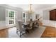 Formal dining room with a chandelier, large windows, and classic wainscoting at 4301 Fairview Oaks Dr, Charlotte, NC 28211