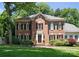 Classic brick home with black shutters, manicured lawn, and inviting front entrance at 4301 Fairview Oaks Dr, Charlotte, NC 28211