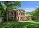 Beautiful brick home with black shutters, lush green lawn, and mature trees at 4301 Fairview Oaks Dr, Charlotte, NC 28211