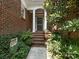 Brick front entrance with lush landscaping and steps at 4301 Fairview Oaks Dr, Charlotte, NC 28211