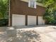 Three-car garage with white doors and brick exterior at 4301 Fairview Oaks Dr, Charlotte, NC 28211