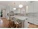 Bright, remodeled kitchen featuring white cabinetry, an island with barstool seating, and stainless steel appliances at 4301 Fairview Oaks Dr, Charlotte, NC 28211