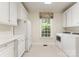 All-white laundry room equipped with modern appliances, ample counter space, and a sunlit window at 4301 Fairview Oaks Dr, Charlotte, NC 28211