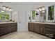 Bathroom with double vanities, granite countertops, wood cabinets, and a window with natural light at 167 Maple View Dr, Troutman, NC 28166