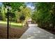 A beautiful stone home is visible at the end of a long driveway lined with mature trees at 167 Maple View Dr, Troutman, NC 28166