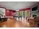 A large living room featuring a pool table, fireplace, red walls, and windows to the outside at 167 Maple View Dr, Troutman, NC 28166