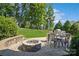 Stone patio with fire pit, outdoor seating, and grill at 17011 Alydar Commons Ln, Charlotte, NC 28278