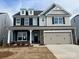 Two-story home with gray siding, stone accents, and a three-car garage at 8736 Acadia Pkwy # 601, Sherrills Ford, NC 28673