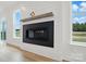 Modern fireplace with a white shiplap surround, wood mantle, and large windows at 8736 Acadia Pkwy # 601, Sherrills Ford, NC 28673