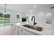 Open kitchen with large island, stainless steel sink, and view into the living room at 8736 Acadia Pkwy # 601, Sherrills Ford, NC 28673