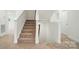 Carpeted staircase with white banisters leads to the upper level, offering a seamless transition between floors at 8736 Acadia Pkwy # 601, Sherrills Ford, NC 28673