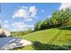 Large backyard featuring a concrete patio and lush green lawn with fencing and mature trees at 16004 Deer River Rd, Charlotte, NC 28278