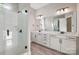 Bathroom featuring a walk-in shower, and double vanity with white cabinets and modern fixtures at 16004 Deer River Rd, Charlotte, NC 28278