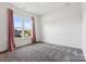 Bright bedroom featuring a large window and plush carpet at 16004 Deer River Rd, Charlotte, NC 28278