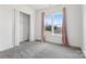 Bright bedroom with gray carpet, closet with white curtains, and a large window with pink curtains at 16004 Deer River Rd, Charlotte, NC 28278