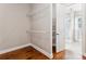 Walk-in closet with wire shelving and hardwood floors. Doorway view of an adjacent bathroom at 16004 Deer River Rd, Charlotte, NC 28278