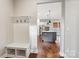 Entryway featuring a built-in bench and coat rack with hardwood floors leading to the kitchen at 16004 Deer River Rd, Charlotte, NC 28278