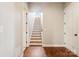 Hardwood staircase with white risers and a view to the upstairs landing at 16004 Deer River Rd, Charlotte, NC 28278