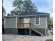 The home's back exterior features a small wooden deck with stairs and gravel, plus convenient under-deck storage at 360 Spring Sw St, Concord, NC 28025