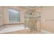 Luxurious bathroom with soaking tub, glass shower, and decorative tile at 5888 Hidden Oaks Ln, Clover, SC 29710