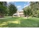 Traditional two-story home with white columns, balconies, lush lawn and mature trees at 5888 Hidden Oaks Ln, Clover, SC 29710