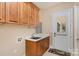 Laundry room with sink, cabinets, and access to the backyard at 5888 Hidden Oaks Ln, Clover, SC 29710