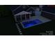 Aerial view of a modern pool with cool lighting and seamless integration with the home at 5888 Hidden Oaks Ln, Clover, SC 29710