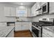 Modern kitchen with white cabinets, granite countertops, and stainless steel appliances at 181 Atwater Landing Dr, Mooresville, NC 28117