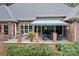 Brick patio with a striped awning, outdoor seating, and landscaping at 4364 Hager Mountain Ln, Iron Station, NC 28080