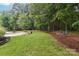 Landscaped backyard with a peaceful sitting area and wooded backdrop at 7025 Willow Trace Ln, Weddington, NC 28104