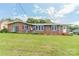 Backyard view of a brick home featuring a screened porch and manicured lawn at 1405 Northcrest Dr, Albemarle, NC 28001