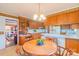 Well-lit kitchen with wooden cabinetry, island bar and adjacent breakfast nook at 1405 Northcrest Dr, Albemarle, NC 28001