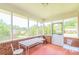 Enclosed porch with seating area and views of the surrounding trees and backyard at 1405 Northcrest Dr, Albemarle, NC 28001