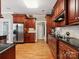 Kitchen boasts dark wood cabinetry, granite countertops, stainless steel appliances, and hardwood floors at 418 Sebring Ct, Belmont, NC 28012