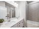 Modern bathroom with double vanity, large mirror, and grey tile at 14949 Holbrooks Rd, Huntersville, NC 28078