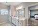 Double vanity bathroom with a large mirror and a view into the bedroom at 14949 Holbrooks Rd, Huntersville, NC 28078