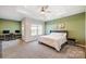 Bright bedroom featuring a workspace, a large bed, and green accent wall at 14949 Holbrooks Rd, Huntersville, NC 28078