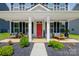 Inviting front porch with red door, and comfortable seating at 14949 Holbrooks Rd, Huntersville, NC 28078