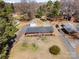 Aerial view of a brick home with a large lot, detached garage, mature trees and a long driveway at 1206 Mineral Springs Rd, Charlotte, NC 28262