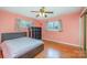 This bedroom features hardwood floors, a modern bed, a storage cube and two windows at 1206 Mineral Springs Rd, Charlotte, NC 28262