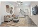 Comfortable living room with a staircase, large rug, and wall decorations at 4861 Blanchard Way, Charlotte, NC 28226