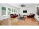 Bright living room with hardwood floors, modern ceiling fan, and large windows overlooking greenery at 6178 Chimney Bluff Rd, Lancaster, SC 29720