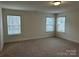 Large bedroom with carpet, three windows for natural light, and neutral paint at 8708 Frank Grier Rd # 53, Charlotte, NC 28215