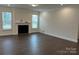 Spacious living room features hardwood floors, a fireplace, and abundant natural light from two large windows at 8708 Frank Grier Rd # 53, Charlotte, NC 28215