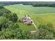 Aerial view of brick home and manicured yard nestled amongst mature trees and fields at 720 Miller Chapel Rd, Salisbury, NC 28147