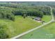 Aerial view of home on a large lot with surrounding fields and mature trees at 720 Miller Chapel Rd, Salisbury, NC 28147